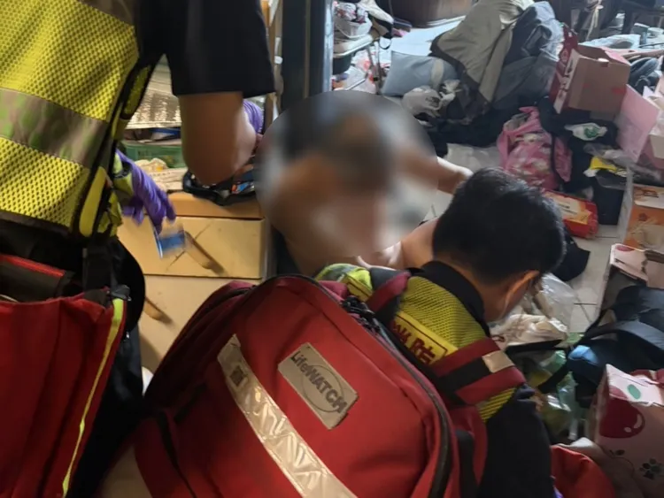 羅男因低血糖癱坐在地，未如常出現在志工場合。翻攝畫面