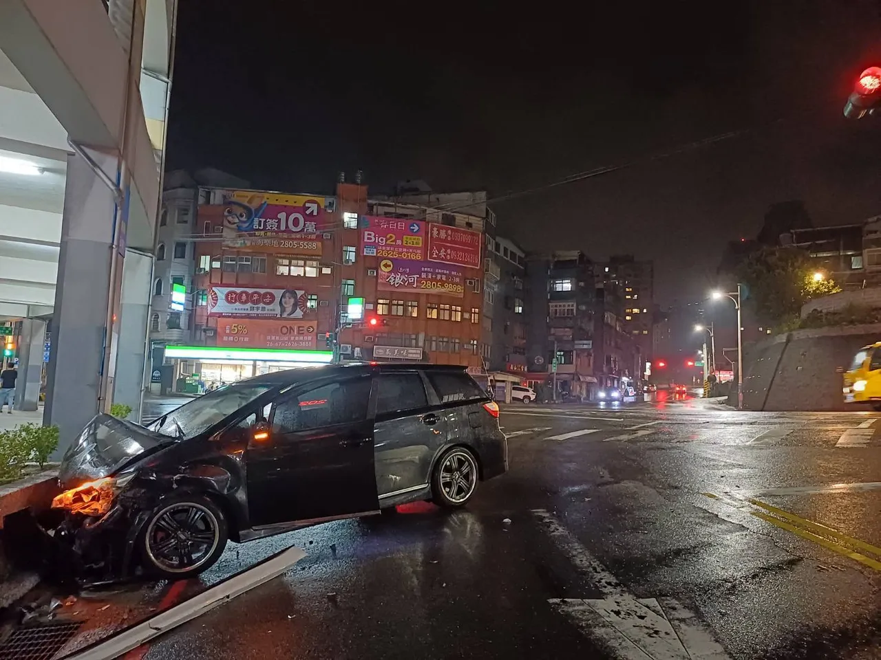 黑色厢型车与转弯的白色BMW碰撞,失控冲向路旁花圃,车头凹陷。翻摄画面