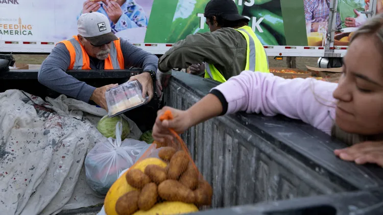 民众领取慈善机关捐助的马铃薯等食品。路透社