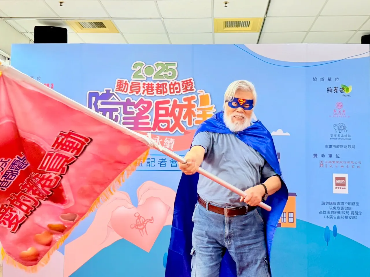 港都电台副董事长孙国祥化身爱心超人，宣告「2025动员港都的爱」公益活动正式启动。翻摄画面