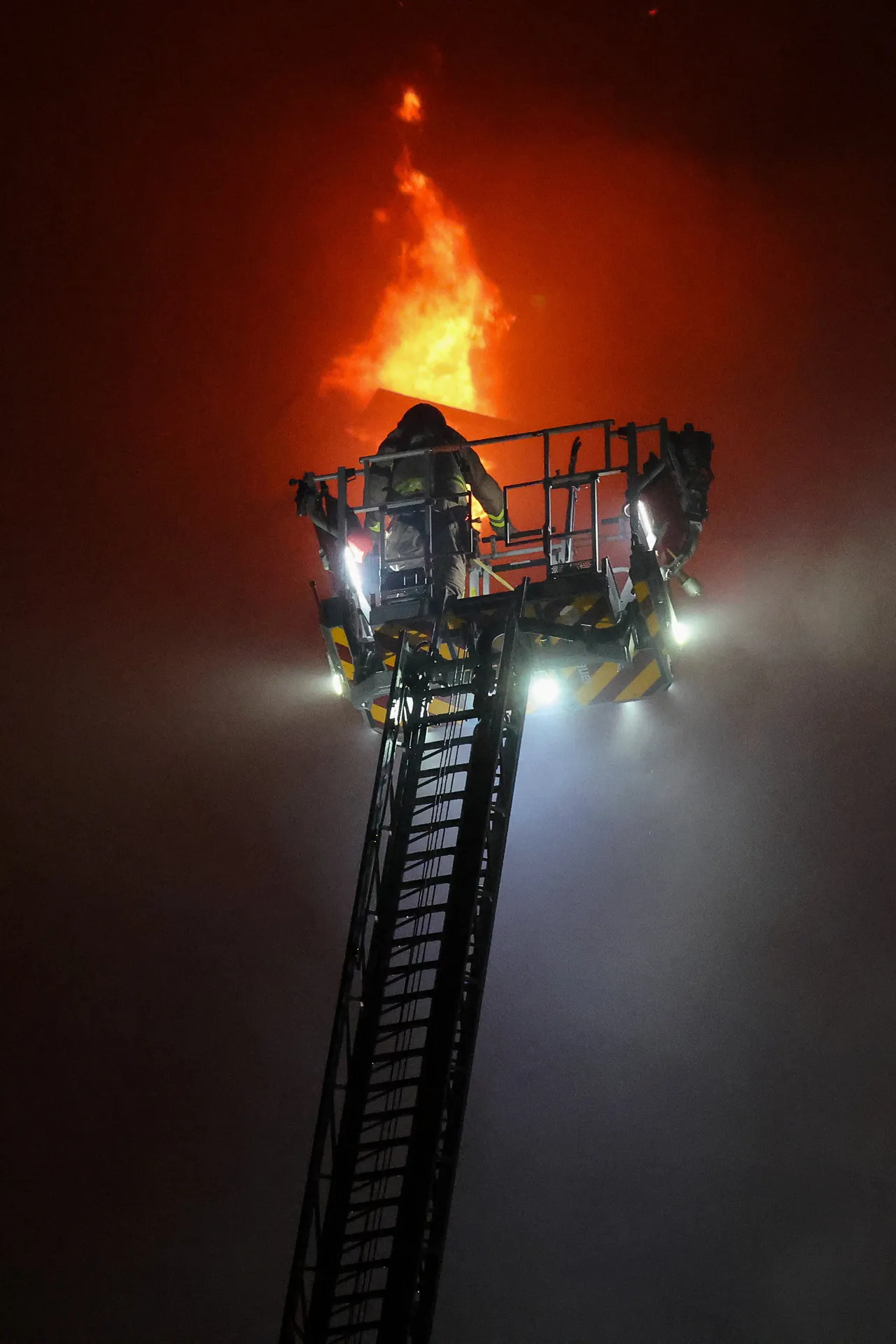 入夜后消防员仍全力救火。路透社