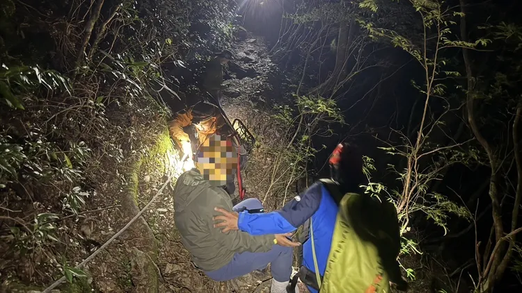 女山友腳傷，救難人員背到檜谷山莊。翻攝畫面