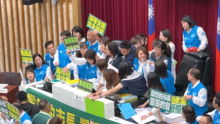 高雄市議會11日交付總預算時，藍營議員上前霸佔主席台，藍綠爆發拉扯衝突。翻攝畫面