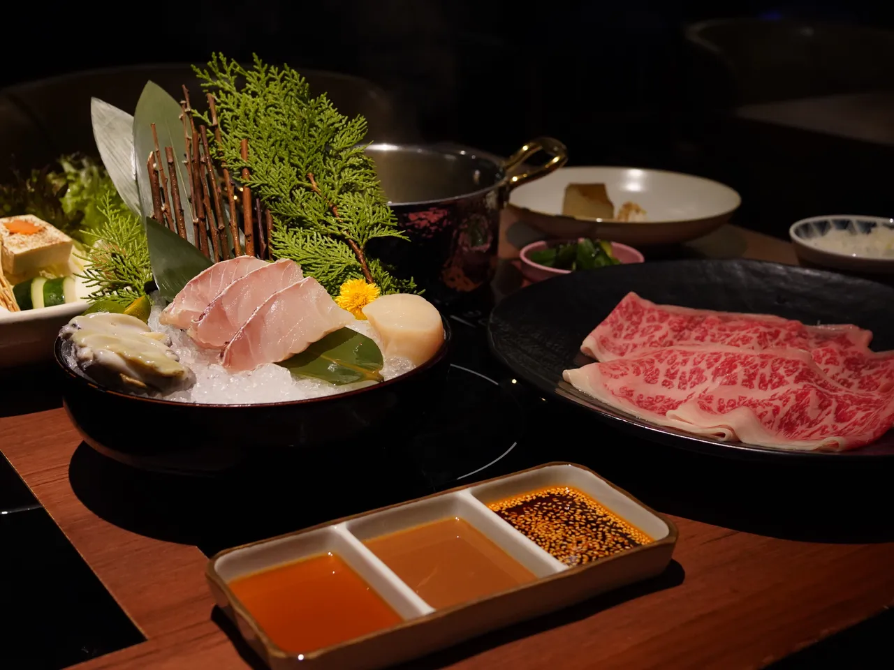 「海陆双拼锅」1580元，以伊比利猪搭配南非鲍鱼、北海道生食级干贝和季节鲜鱼，同时提供现煮杂炊的桌边服务，米粥吸收食材精华、鲜香饱满。业者提供