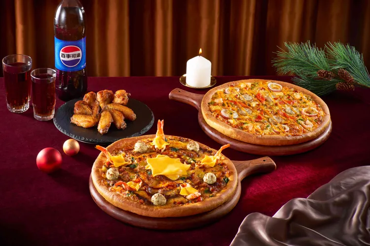 「聖誕跨年大套餐」內含嫩牛大蝦起司比薩，以及另一個大披薩和副食組合。必勝客提供