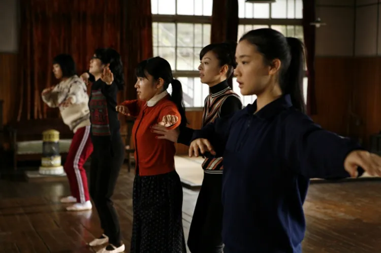 蒼井優（右）片中飾演礦工場的年輕女孩，為了家鄉練草裙舞。華映娛樂提供