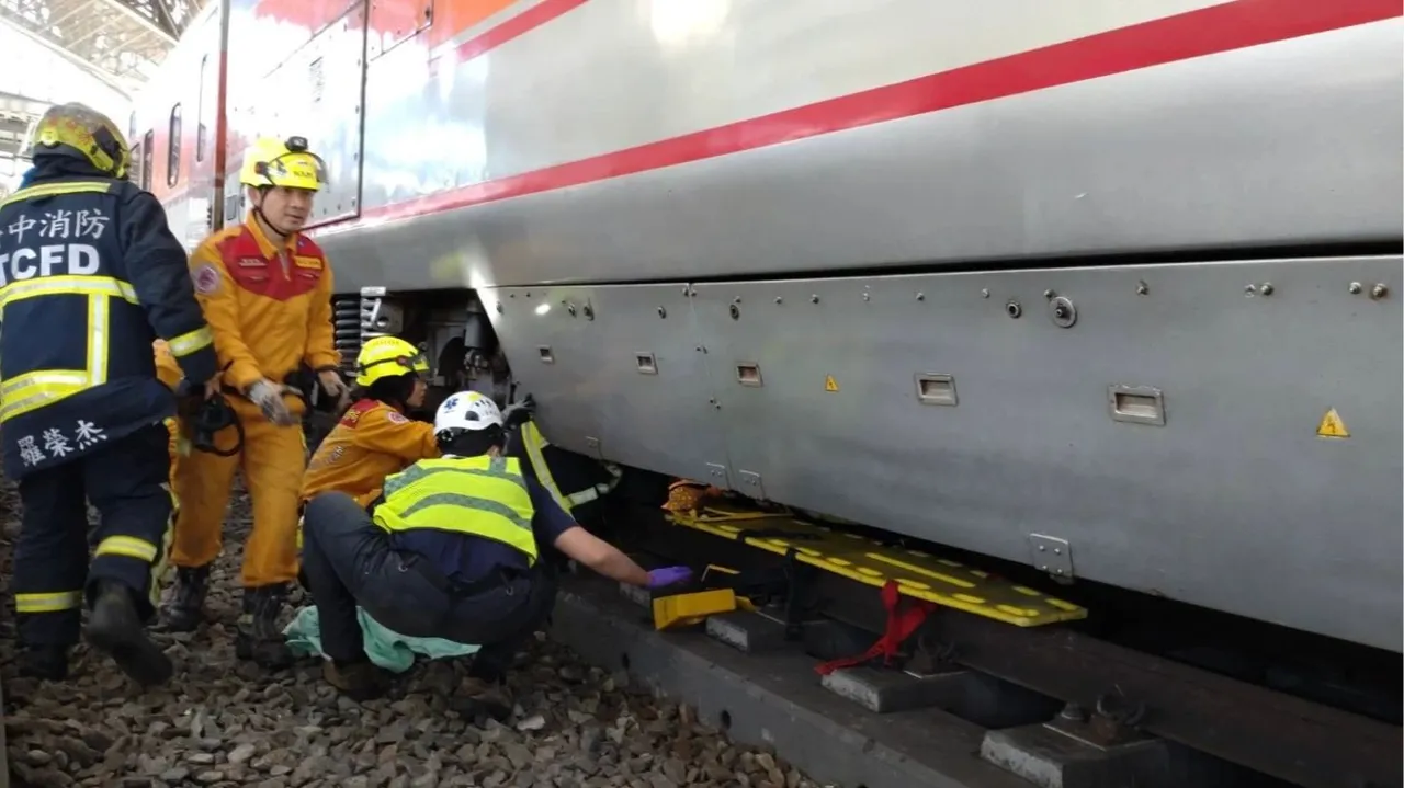 警消抢救受困自强号车底的白姓老妇。民众提供