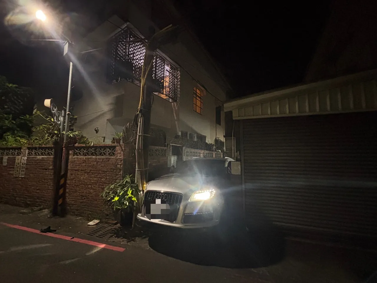 奧迪休旅車卡在電桿與牆垣之間進退不得。民眾提供