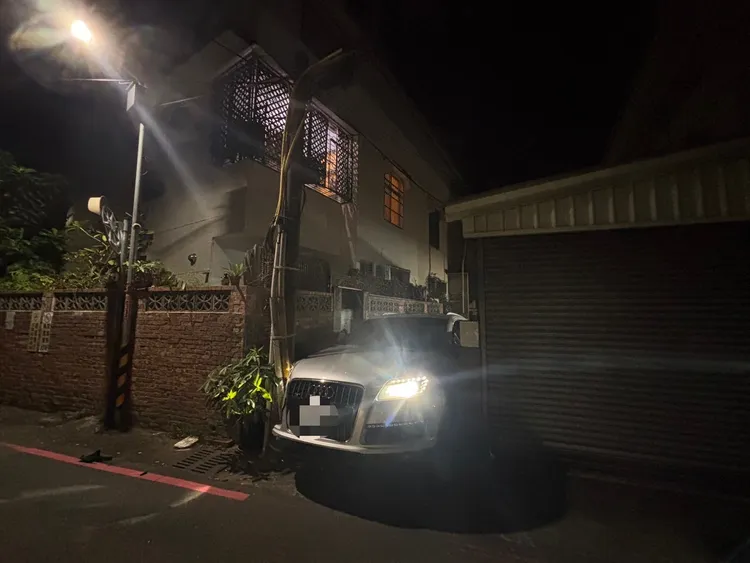 奧迪休旅車卡在電桿與牆垣之間進退不得。民眾提供