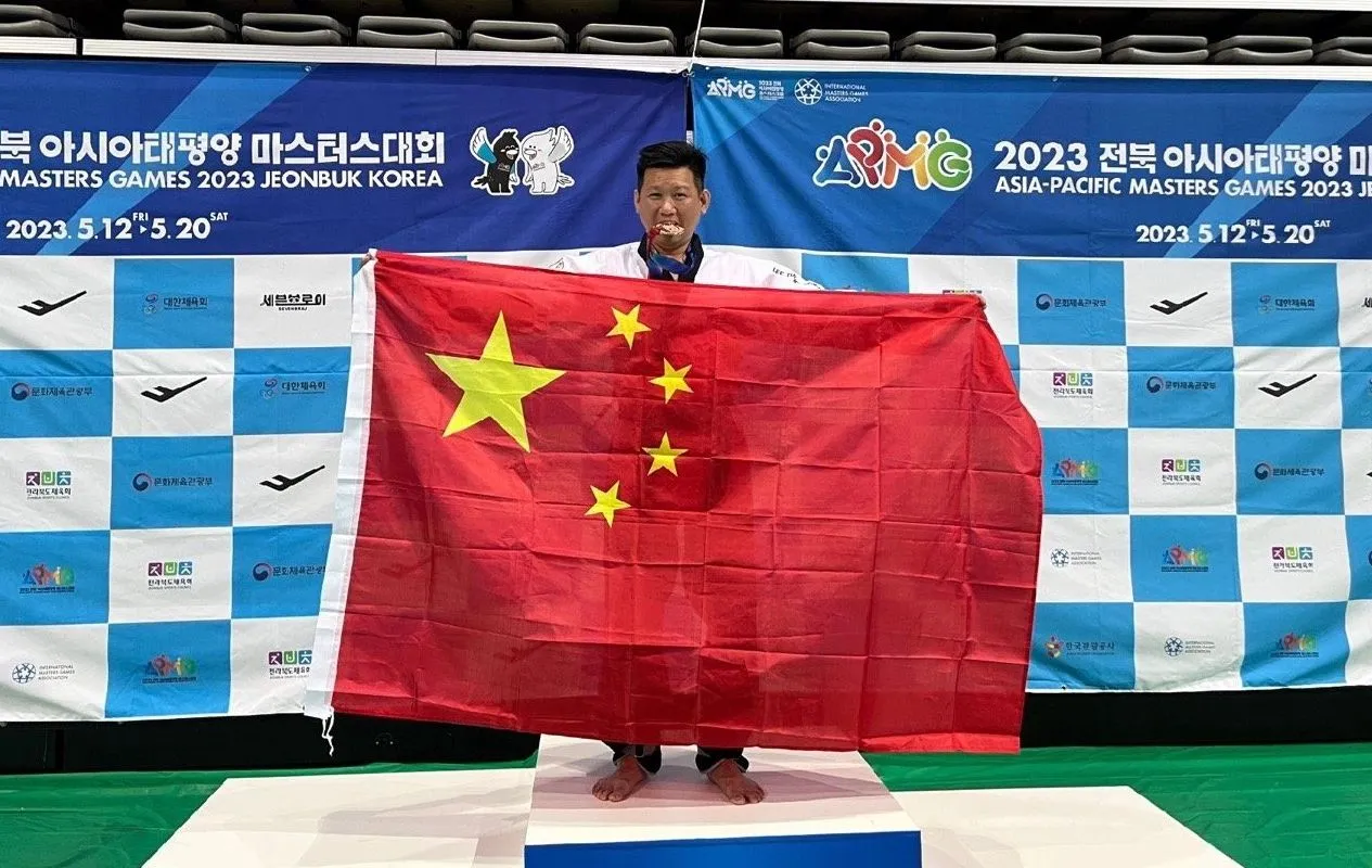 前跆拳道國手李東憲2023年亞太壯年運動會領獎時拿著五星旗。翻攝微博