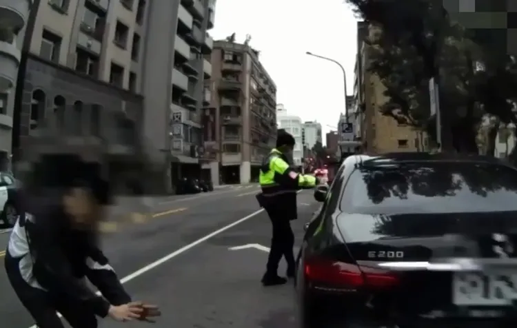 男子（左）因路倒，警方到场协助其搭计程车。翻摄画面