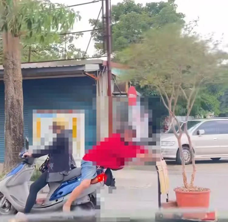 阿伯背坐在机车上拉手推车载运树葡萄。大溪警分局提供