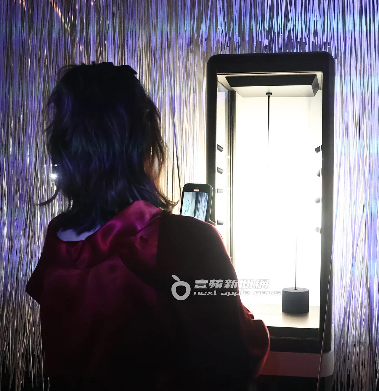 Melody拿出手机拍摄珠宝展。特勤中心摄