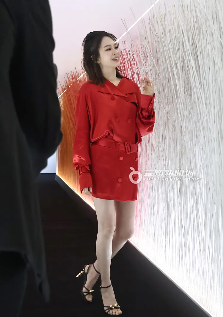 Melody展現白皙鉛筆腿，當天穿的是Ferragamo紅色短款絲綢風衣短裙裝。特勤中心攝