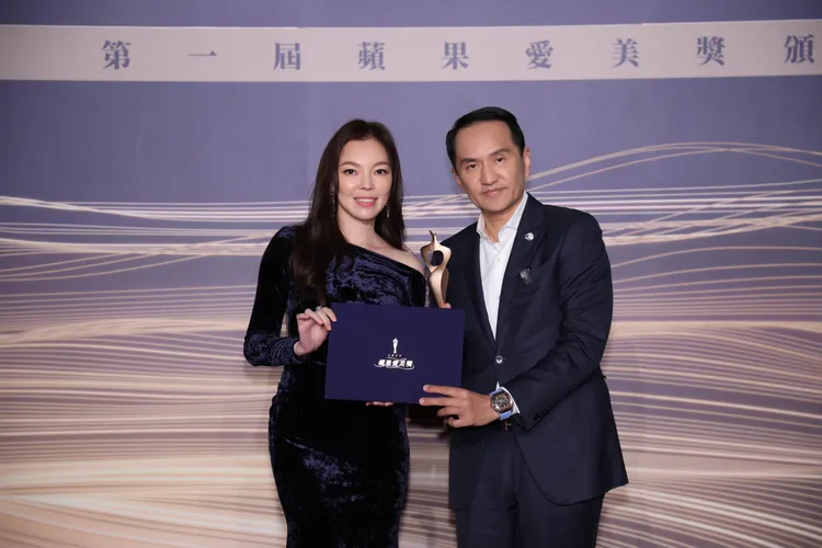 愛爾麗集團董事長常如山（右）獲得「蘋果愛美獎」特別頒發的公益大使獎，自曾馨瑩（左）手中接下獎盃。攝影中心攝