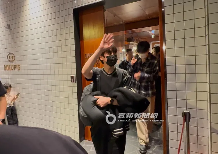 凌晨1點多，圭賢手拿圍脖靠枕走出餐廳跟粉絲們揮揮手道別。特勤中心攝