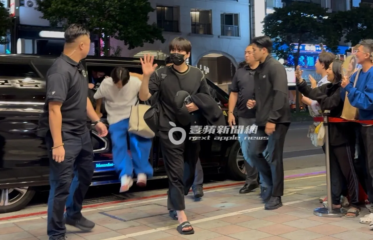 圭賢穿著拖鞋，手上抱著外套十分休閒，面對粉絲開心揮揮手。特勤中心攝