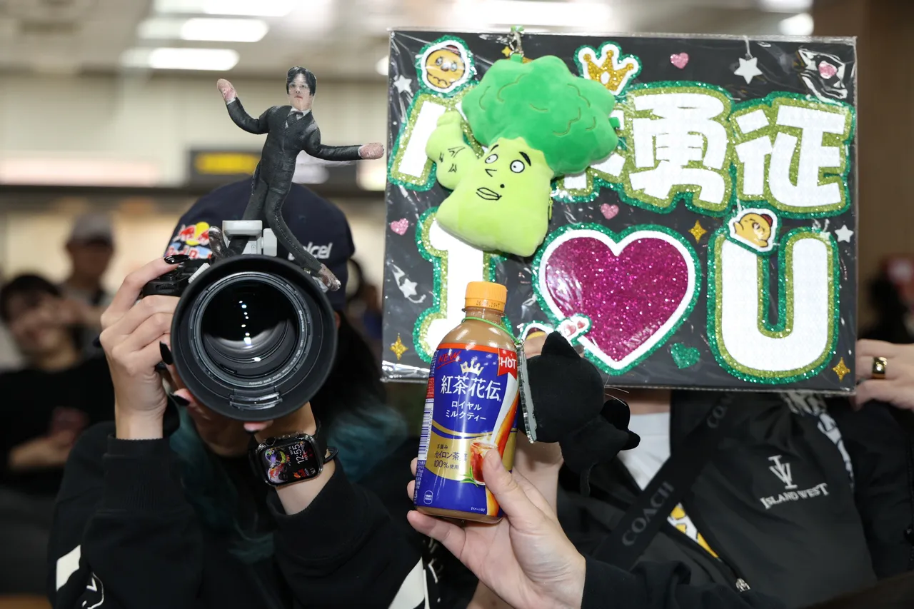 有粉丝在镜头上放八木勇征的立牌及「筋肉花椰菜」玩偶接机。彭欣伟摄