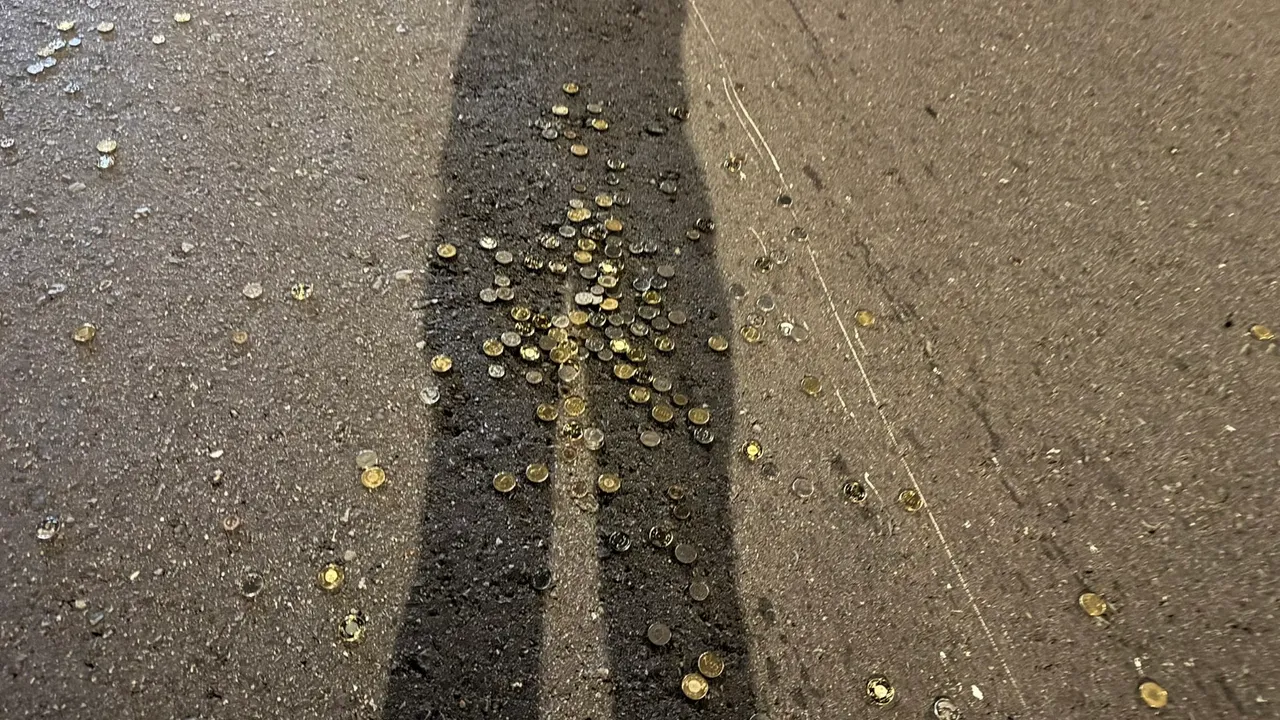 硬币掉落路面上。翻摄画面