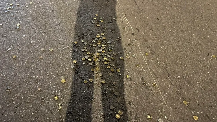 硬幣掉落路面上。翻攝畫面