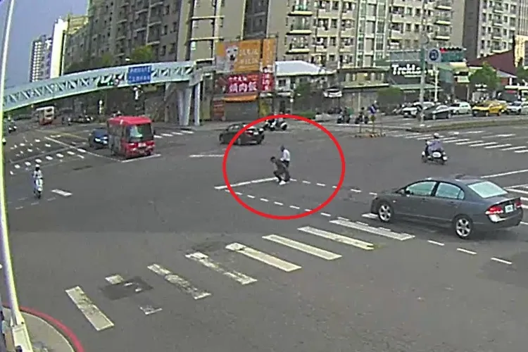 陳翁站在車水馬龍的馬路中央險象環生，路人見狀將他帶往路邊暫歇並報警。翻攝畫面