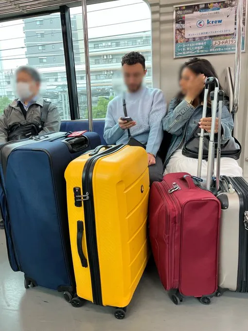 帶著超大行李箱搭電車的觀光客。X