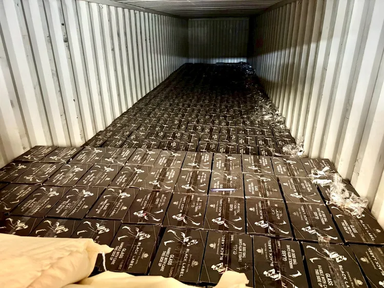 櫃門前兩排處以塑膠粒等貨物掩飾酒品。翻攝畫面