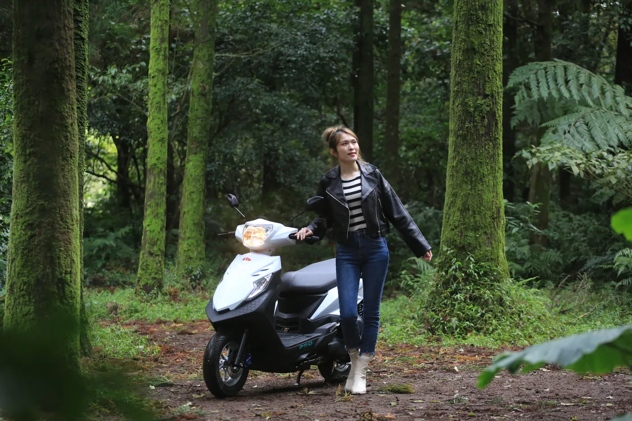 Anica骑著PGO iSavR 125在森林小径停下脚步，静静享受被树影包围的片刻，像是把城市步调暂时放在身后。林浩升摄