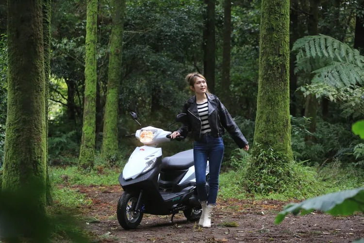 Anica騎著PGO iSavR 125在森林小徑停下腳步，靜靜享受被樹影包圍的片刻，像是把城市步調暫時放在身後。林浩昇攝