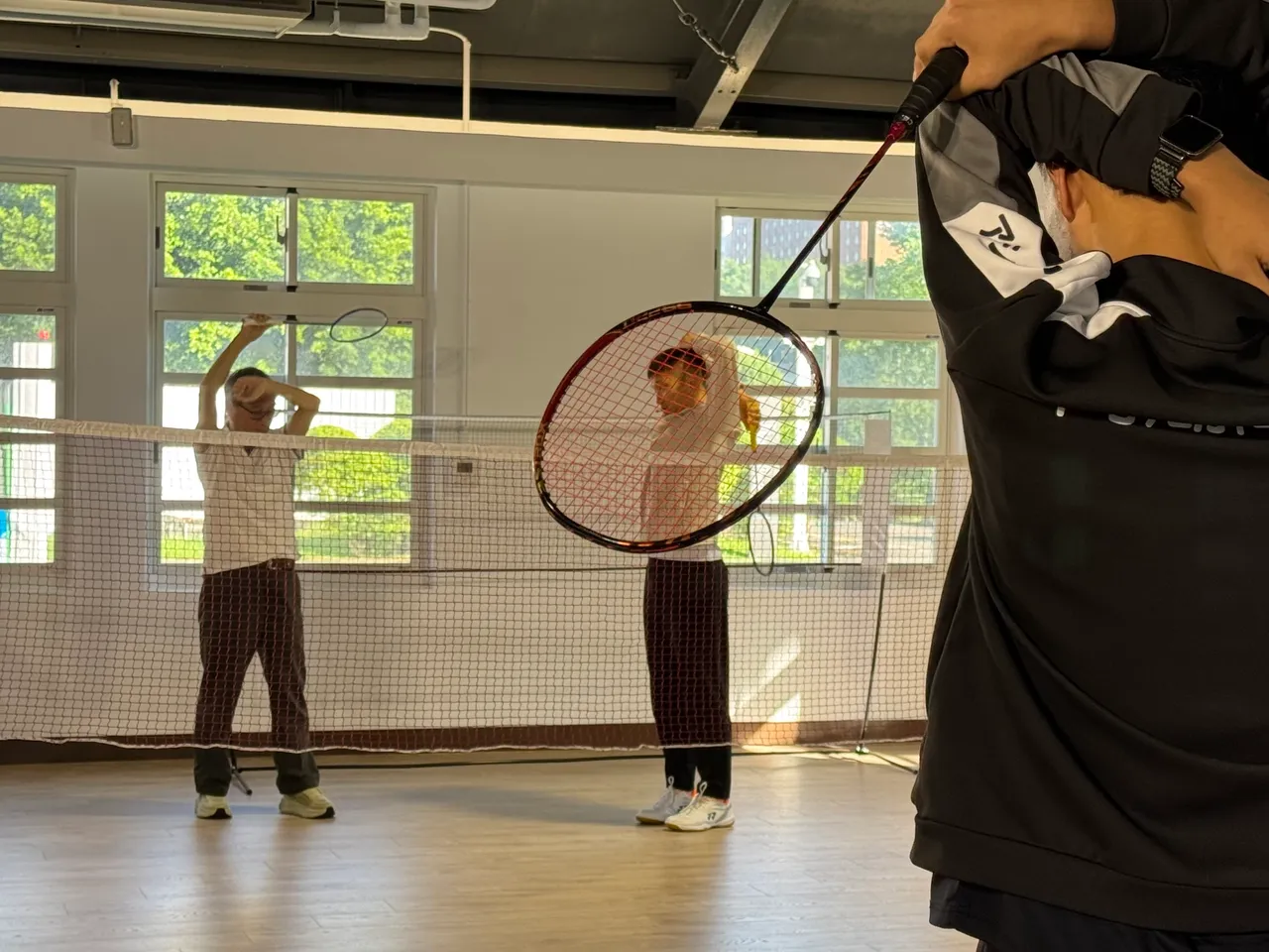 两位部长与内湖高中羽球社学生切磋前先热身。张彩茜摄