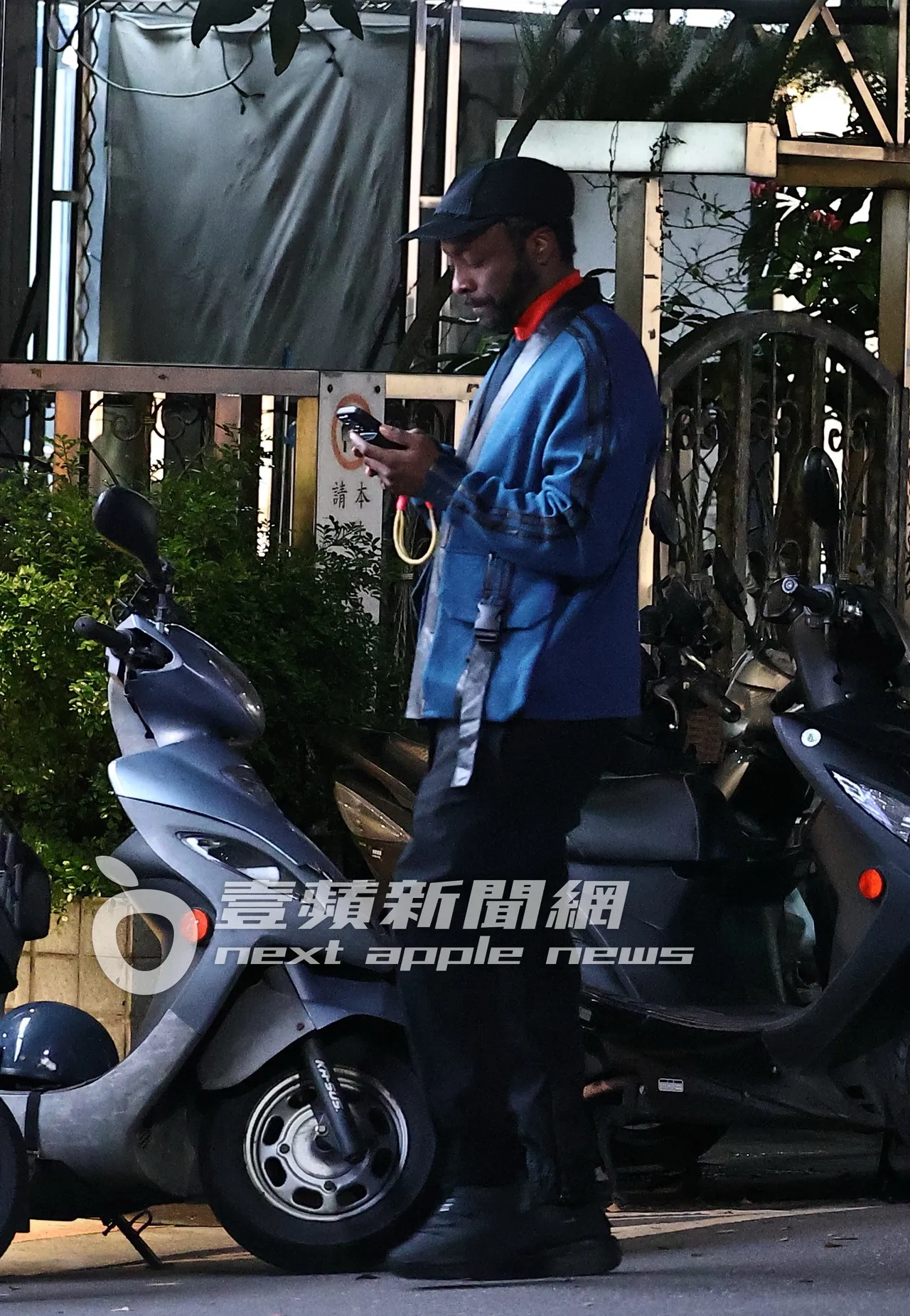 團員will.i.am站在街邊滑手機。特勤中心攝