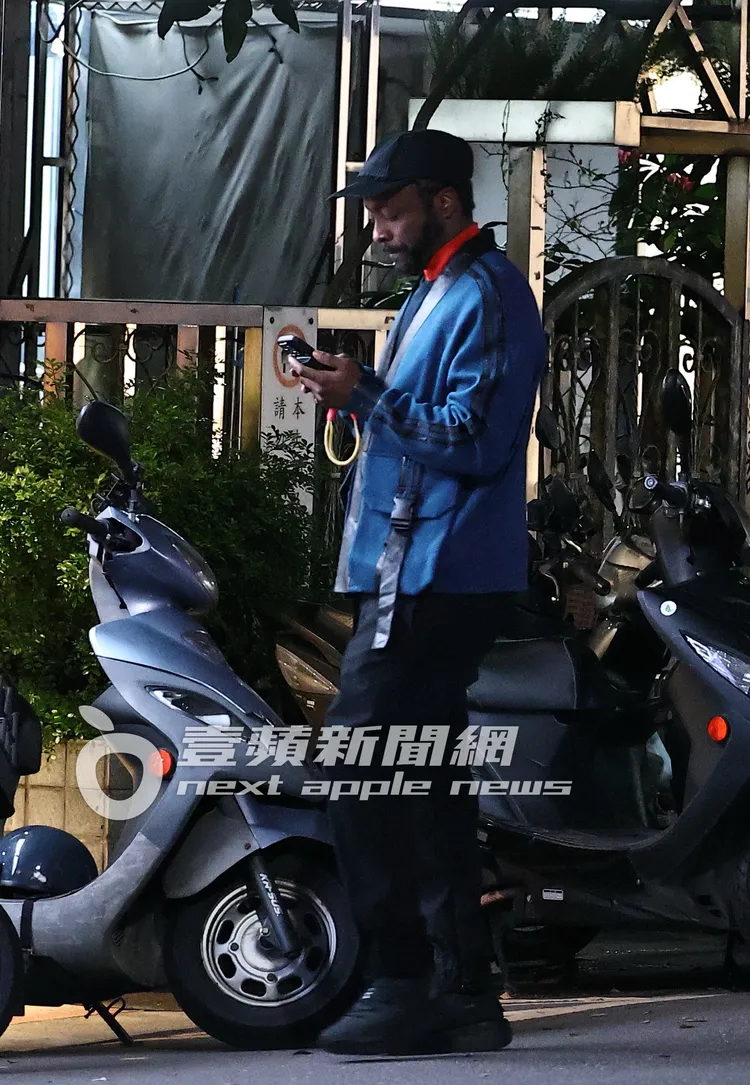 團員will.i.am站在街邊滑手機。特勤中心攝