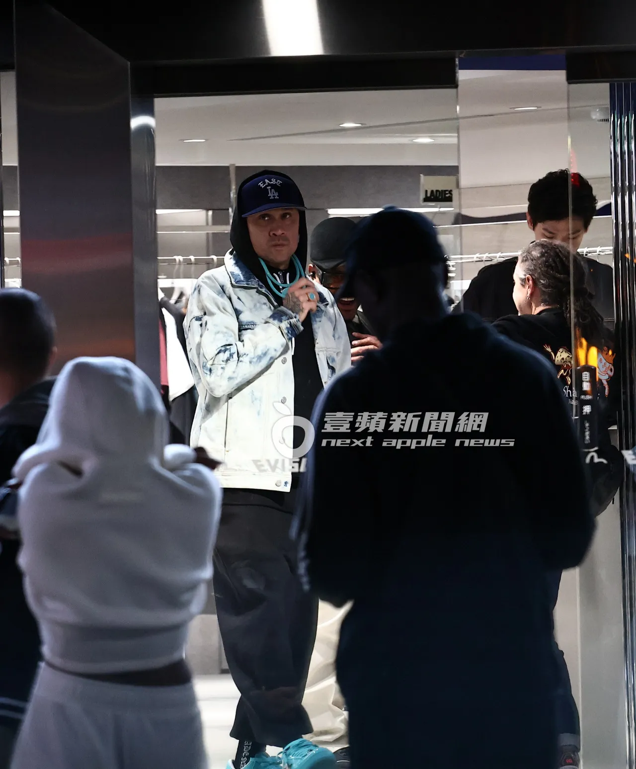 團員Taboo（左）逛完服飾店，走出店外。特勤中心攝