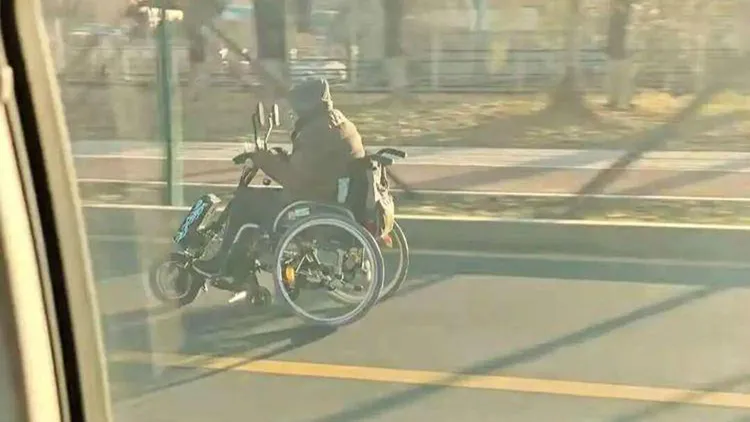 吉林一名汽車駕駛，開車行駛時被一名乘坐電動輪椅的老人超越。翻攝自微博