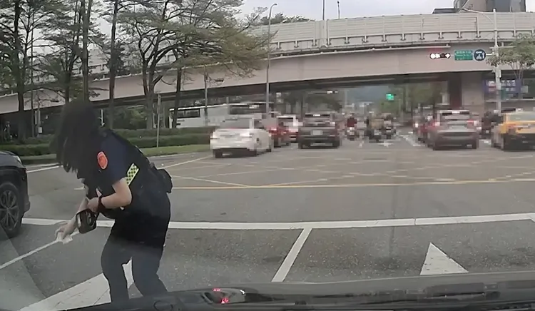 警方帮忙拾取散落路面的纸钞。翻摄画面