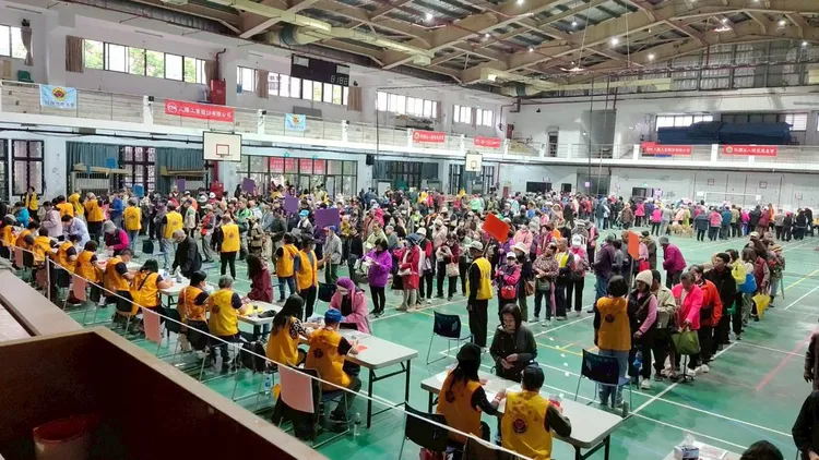 志工在光復商工發放慰問金，花蓮縣警察局鳳林分局光復分駐所派出多位警力維持秩序。業者提供