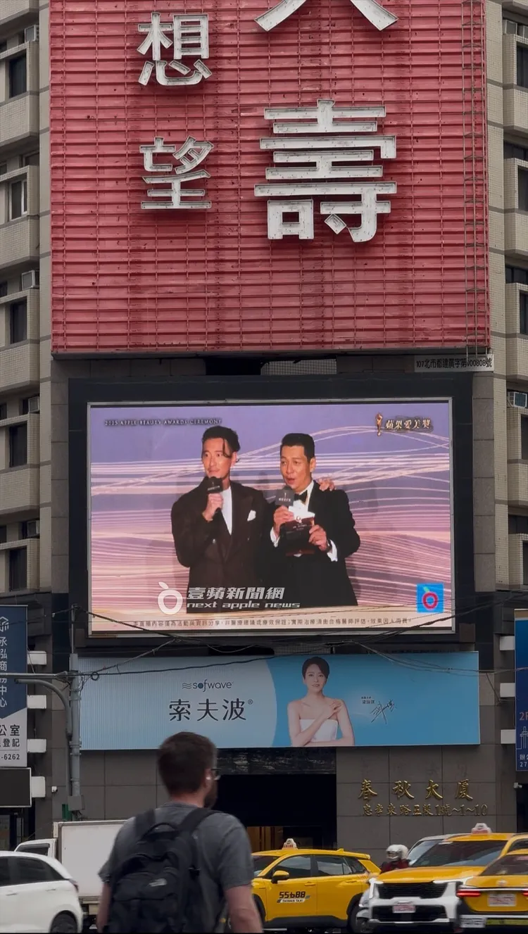 臺北市政府轉運站旁大型螢幕看板，民眾紛紛駐足觀看。攝影中心攝