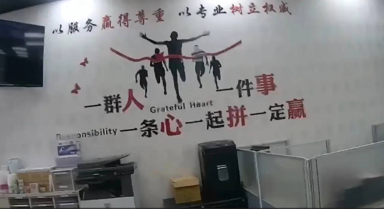 黑帮所操控的承益融资公司内墙上贴著团结标语，用简体字鼓励大家要一条心一起拚就一定赢。翻摄画面