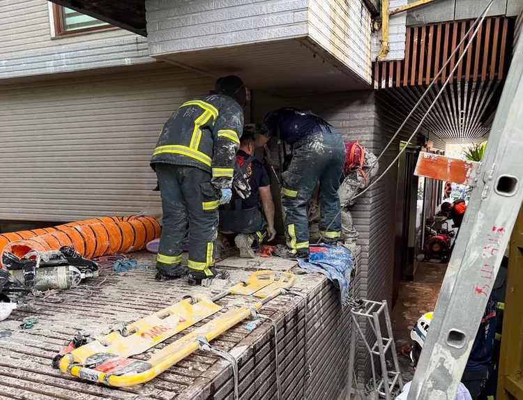 消防人员获报到场，将2工人送医。翻摄画面