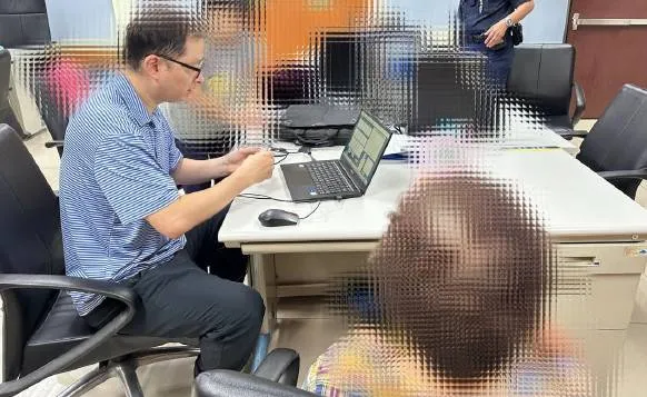 侦查队人员协助老妇人指纹建档。翻摄画面