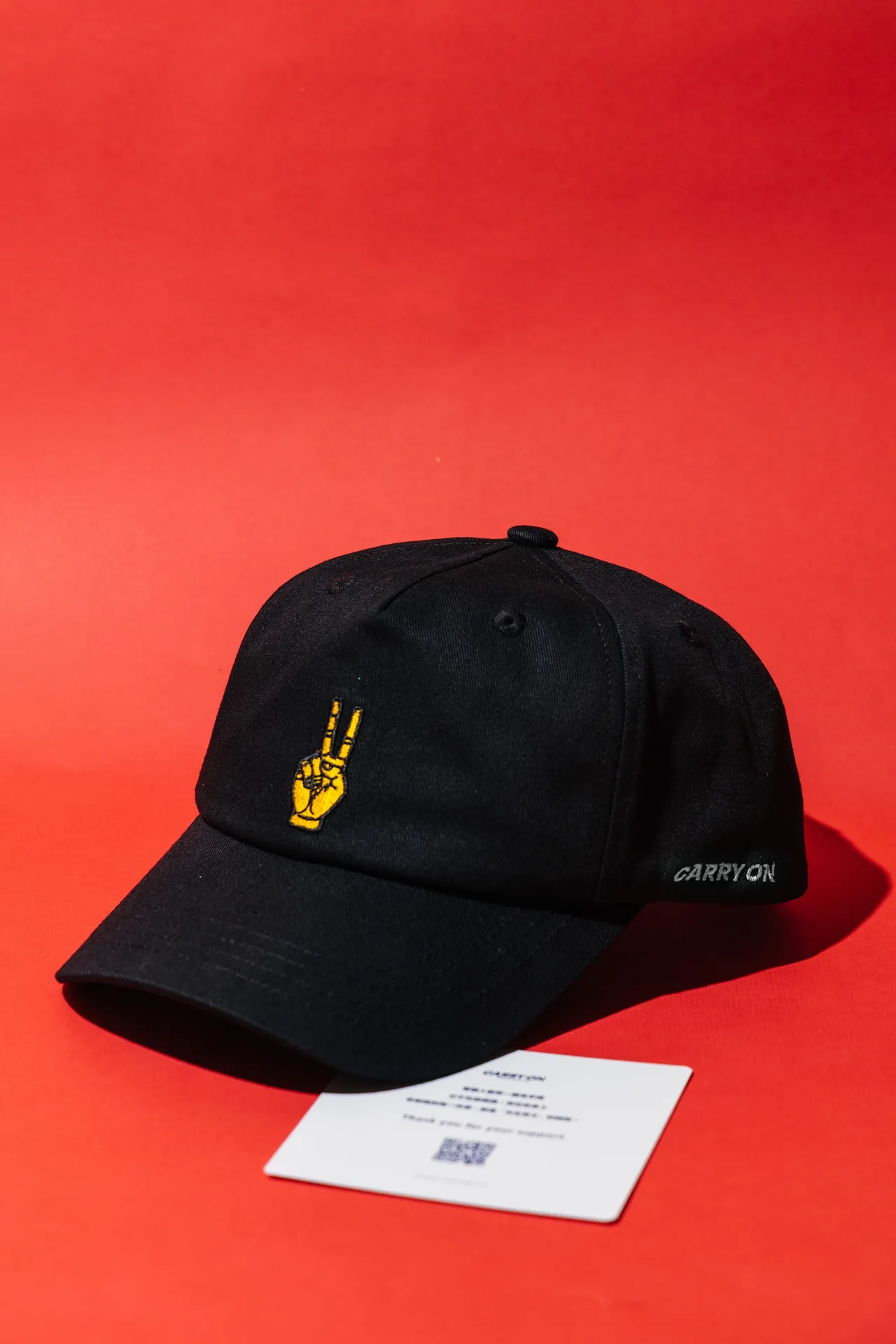 黑色帽棒球帽在正面运用金色刺绣直点「金手指」主题。品牌提供