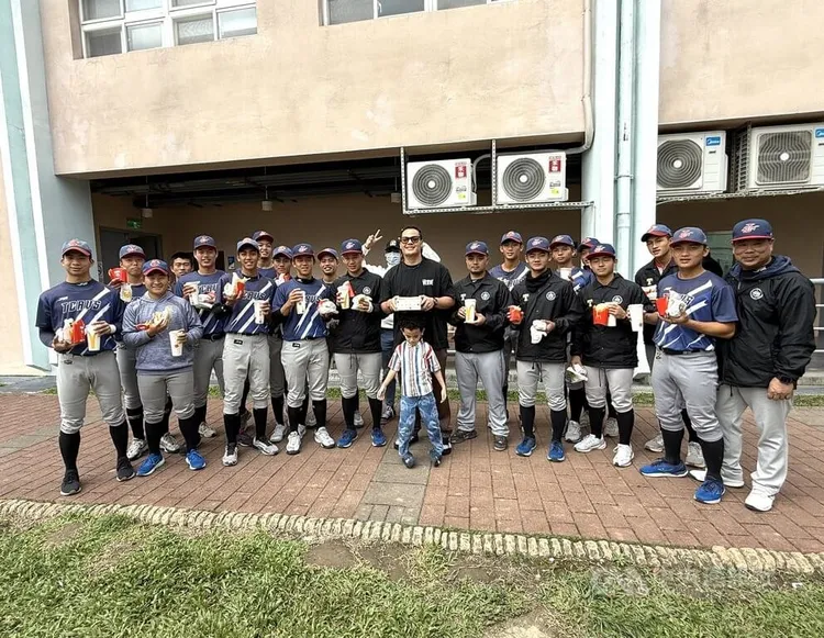 黑豹旗青棒賽興大附農22日16強與台東體中交手，興大附農畢業大學長張育成（中）送麥當勞替學弟打氣。中央社