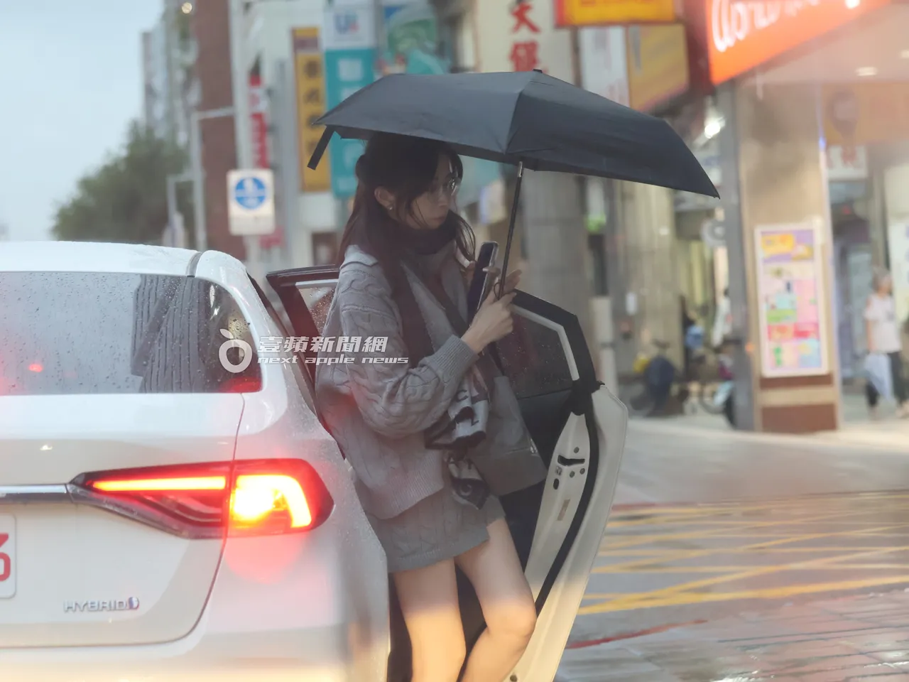 下車時，王乃伃將雨傘撐起。特勤中心攝