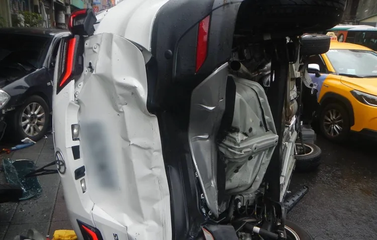 白色小客車遭推擠翻覆。翻攝畫面
