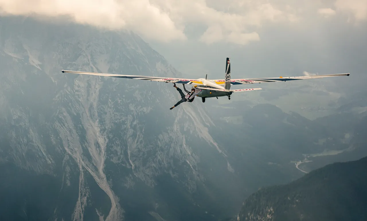 Domen Škofic从驾驶舱后座跃出后在左侧机翼开始攀登，环绕并穿梭于滑翔机的两侧机翼下方。业者提供