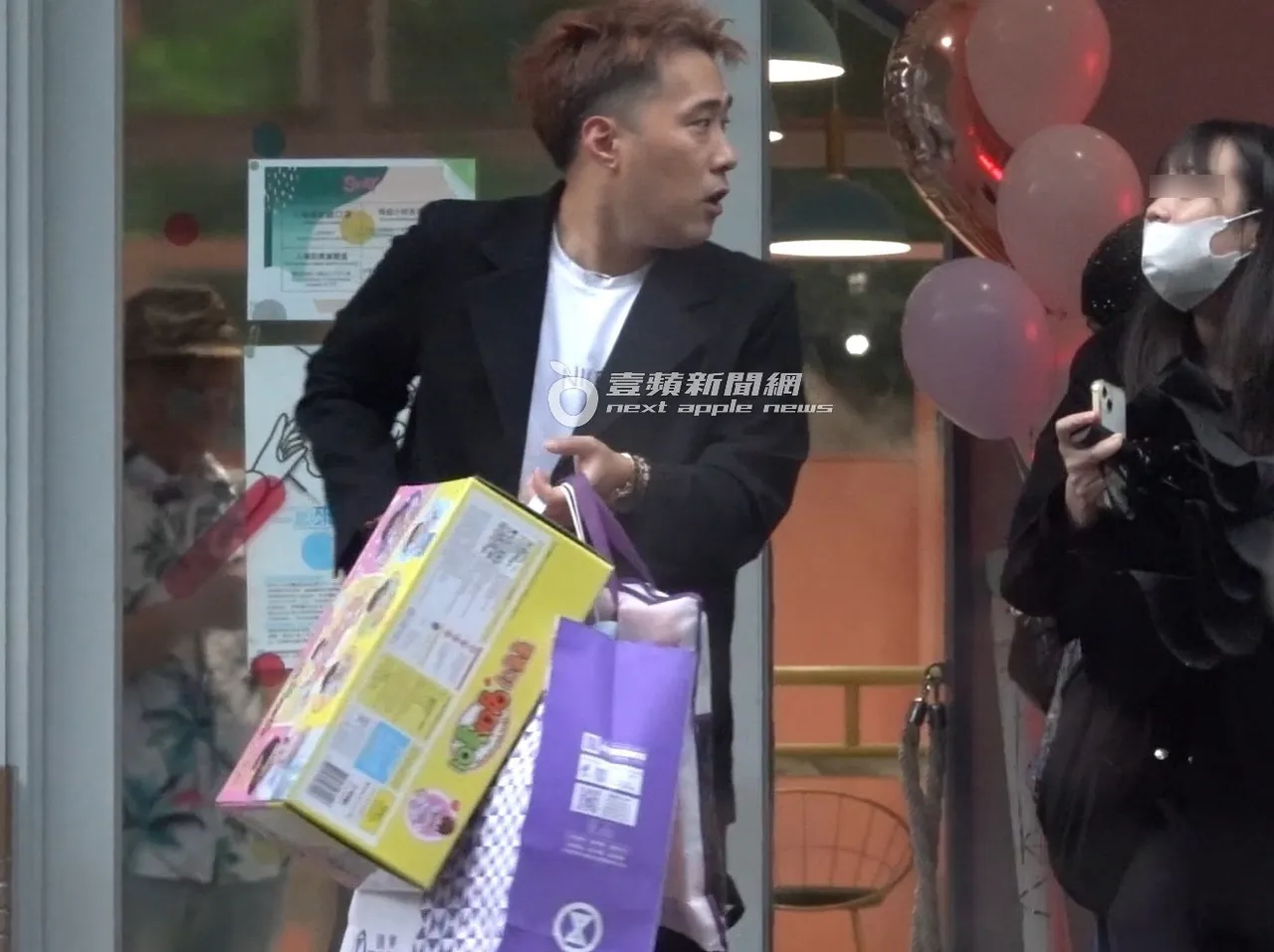 余祥铨提著好几袋女儿收到的赞助品先离开会场去取车。特勤中心摄