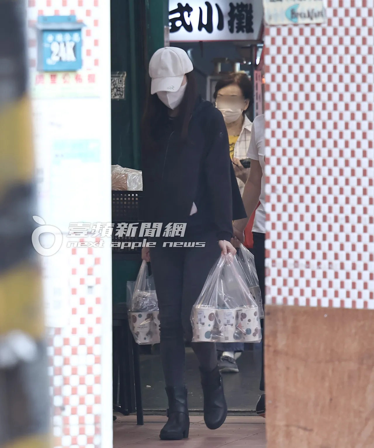 曾馨莹两手各提一袋珍珠鲜奶离开饮料店。特勤中心摄