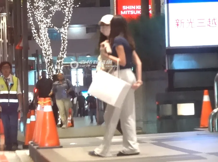 曾馨瑩和妞妞皆是素色穿著，妞妞左手勾著一個紙袋。特勤中心攝