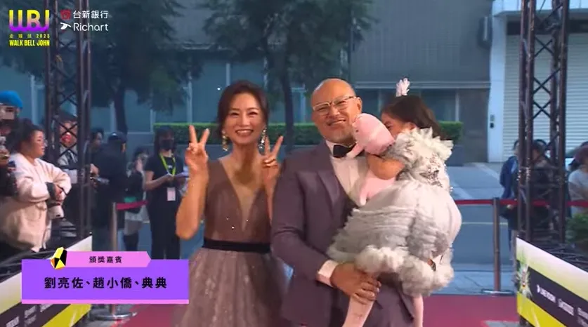 典典在爸爸懷裡，害羞得臉埋進娃娃，非常可愛。翻攝自走鐘獎YT