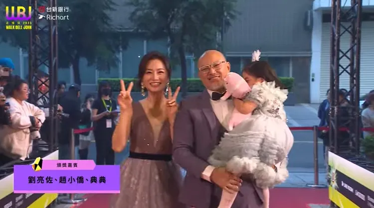 典典在爸爸懷裡，害羞得臉埋進娃娃，非常可愛。翻攝自走鐘獎YT